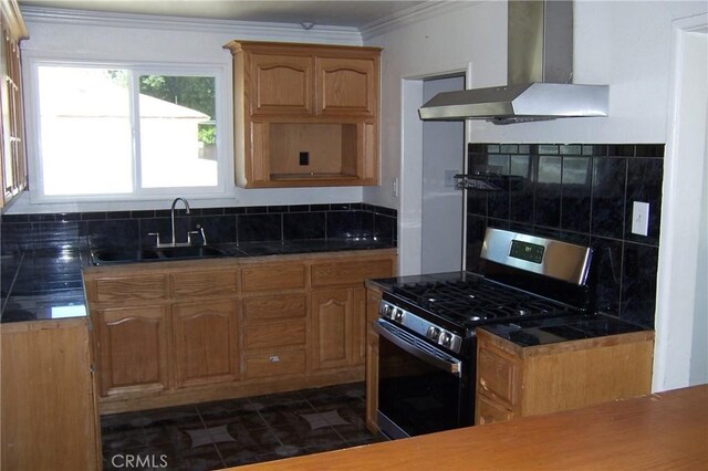1208 W 23rd St, San Bernardino, CA 92405 - kitchen with stainless steel range with gas stovetop, wall chimney range hood, crown molding, dark tile patterned floors, and tasteful backsplash