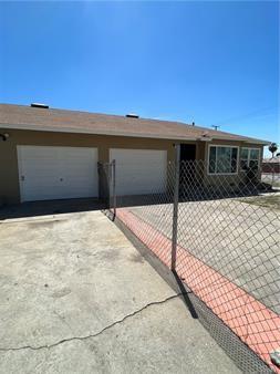view of front facade featuring driveway, a garage, and fence