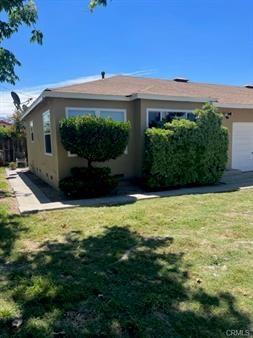 exterior space with stucco siding, an attached garage, and a lawn