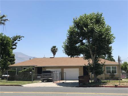 single story home featuring driveway, a fenced front yard, and an attached garage