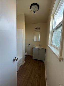 hall featuring a sink and wood finished floors