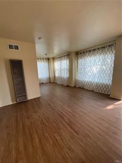 spare room featuring visible vents and wood finished floors