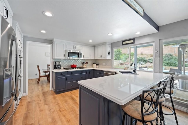 710 W Country Hills Dr W, La Habra, CA 90631 - kitchen with appliances with stainless steel finishes, gray cabinetry, a sink, a peninsula, and white cabinetry