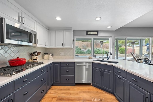 710 W Country Hills Dr W, La Habra, CA 90631 - kitchen with plenty of natural light, appliances with stainless steel finishes, white cabinetry, a sink, and light wood-style flooring