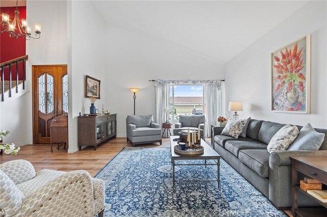 710 W Country Hills Dr W, La Habra, CA 90631 - living area featuring an inviting chandelier, stairs, wood finished floors, baseboards, and high vaulted ceiling