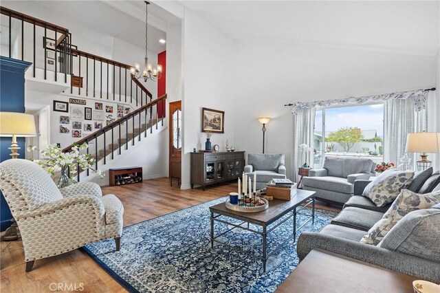 710 W Country Hills Dr W, La Habra, CA 90631 - living area with an inviting chandelier, wood finished floors, baseboards, high vaulted ceiling, and stairway