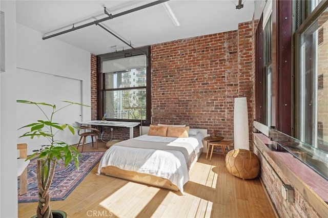 460 S Spring St Unit 302, Los Angeles, CA 90013 - bedroom featuring brick wall and wood-type flooring