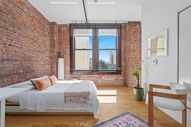 460 S Spring St Unit 302, Los Angeles, CA 90013 - bedroom featuring hardwood / wood-style floors and brick wall