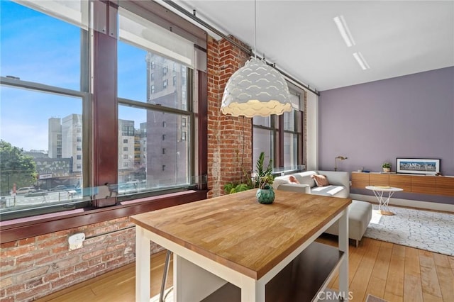 460 S Spring St Unit 302, Los Angeles, CA 90013 - dining space with a city view, brick wall, and wood-type flooring