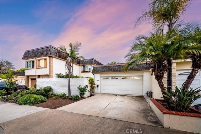 28 Brisbane Way, Irvine, CA 92612 - view of front of house with mansard roof, stucco siding, an attached garage, and driveway