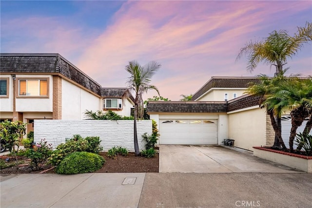 28 Brisbane Way, Irvine, CA 92612 - view of front property featuring stucco siding, mansard roof, a garage, and concrete driveway