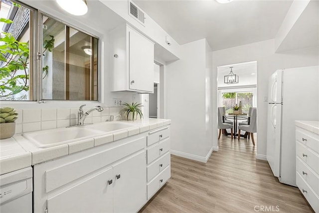 28 Brisbane Way, Irvine, CA 92612 - kitchen featuring freestanding refrigerator, tile counters, white cabinets, and light wood-style floors
