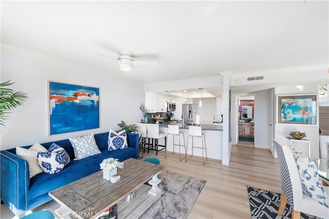 26056 Vista Dr E Unit 64, Dana Point, CA 92624 - living room with a ceiling fan, crown molding, light wood-style flooring, baseboards, and visible vents