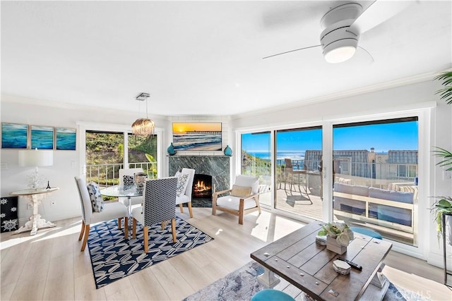 26056 Vista Dr E Unit 64, Dana Point, CA 92624 - dining space featuring a premium fireplace, wood finished floors, a ceiling fan, and ornamental molding