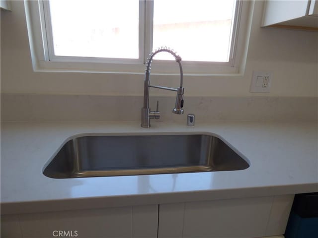 interior details featuring light countertops and a sink