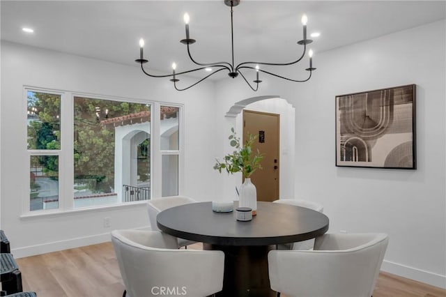 3649 Mount Vernon Dr, View Park, CA 90008 - dining space featuring baseboards, light wood-type flooring, a notable chandelier, and arched walkways