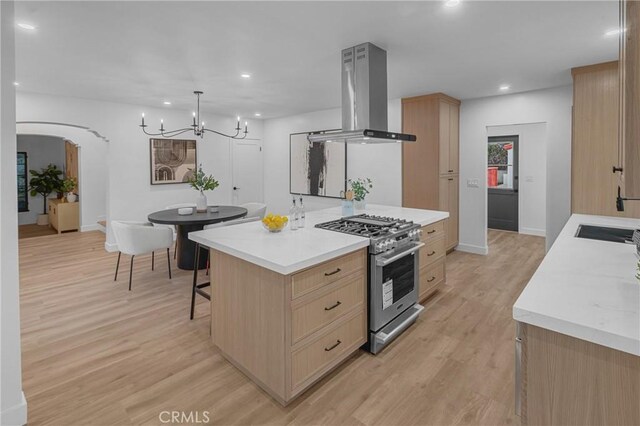 3649 Mount Vernon Dr, View Park, CA 90008 - kitchen featuring stainless steel stove, light countertops, wall chimney range hood, an inviting chandelier, and light brown cabinetry