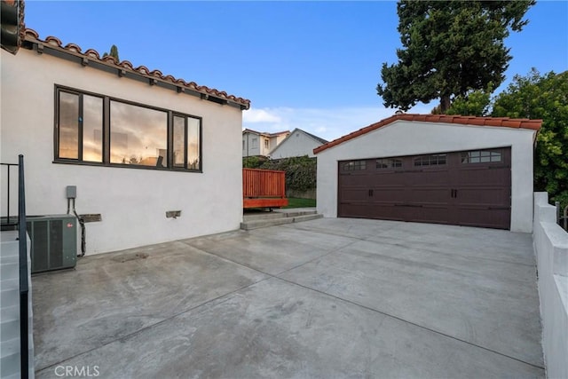 3649 Mount Vernon Dr, View Park, CA 90008 - view of home's exterior featuring a tile roof, central air condition unit, stucco siding, an outbuilding, and a garage