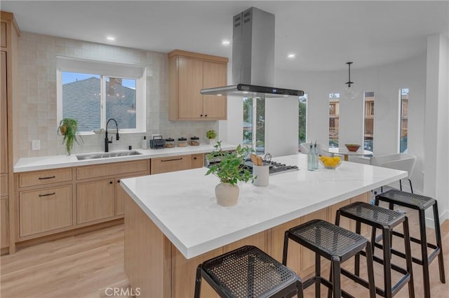 3649 Mount Vernon Dr, View Park, CA 90008 - kitchen with island exhaust hood, light brown cabinetry, a breakfast bar, and a sink