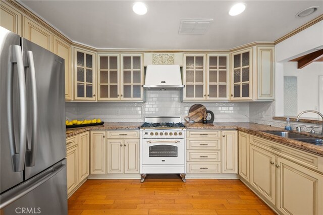 3569 Kelton Ave, Los Angeles, CA 90034 - kitchen featuring cream cabinets, freestanding refrigerator, under cabinet range hood, gas stove, and a sink