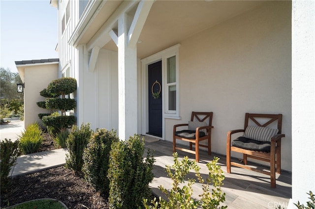 property entrance with stucco siding and a porch