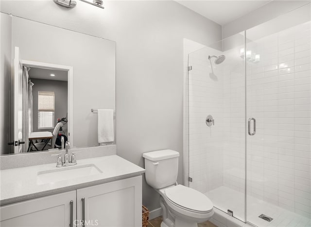 bathroom featuring a shower stall, toilet, and vanity