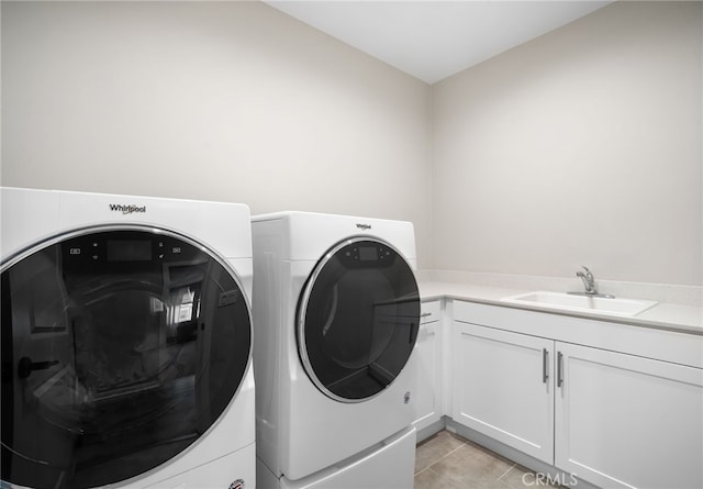 laundry area featuring washer and dryer, cabinet space, a sink, and light tile patterned floors