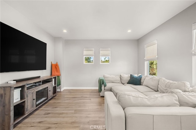 living area with light wood finished floors, baseboards, and recessed lighting