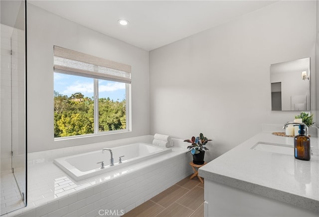 full bathroom with recessed lighting, vanity, and a garden tub