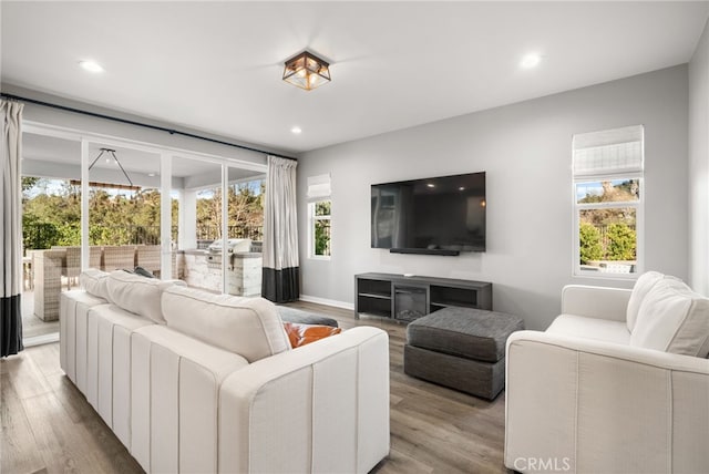 living room with recessed lighting, baseboards, and wood finished floors