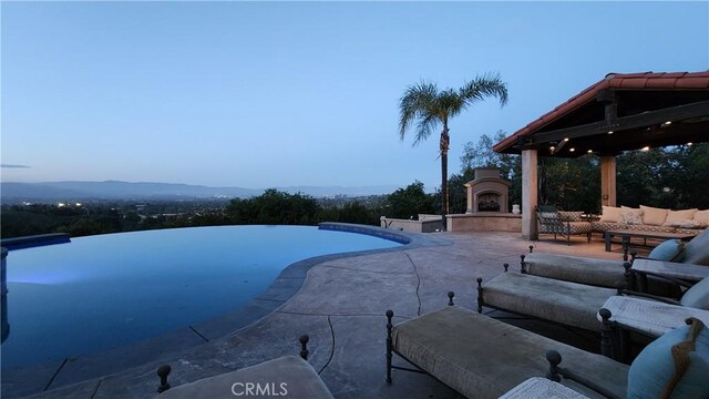 23815 Park Belmonte, Calabasas, CA 91302 - view of pool with a patio, an outdoor living space with a fireplace, and an infinity pool