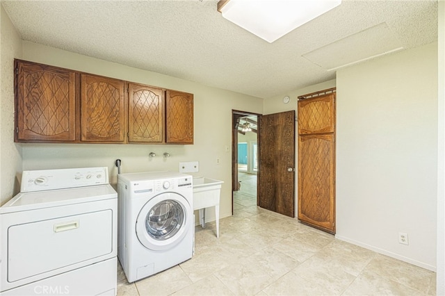 43421 45th St W, Lancaster, CA 93536 - laundry area featuring cabinet space, washer and clothes dryer, a textured ceiling, baseboards, and light tile patterned floors