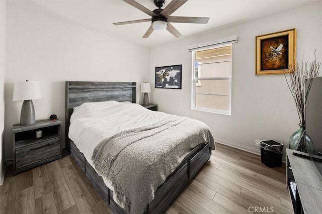 bedroom with baseboards, wood finished floors, and a ceiling fan