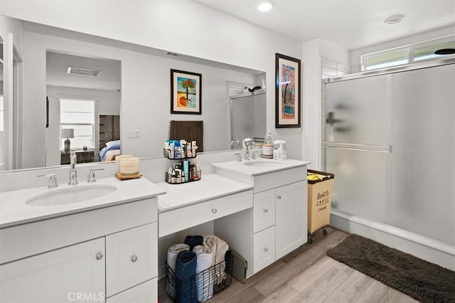 full bath featuring visible vents, a shower stall, connected bathroom, wood finished floors, and vanity