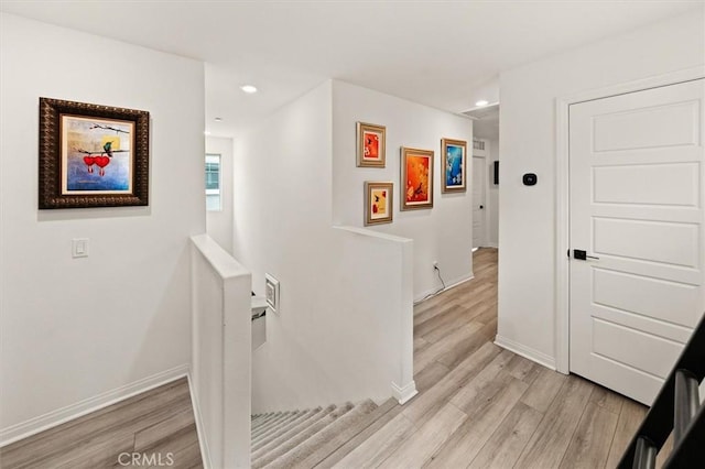 hall featuring baseboards, an upstairs landing, recessed lighting, and light wood finished floors