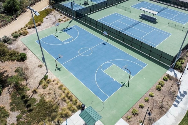 view of sport court with a tennis court, fence, and community basketball court
