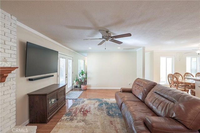 living room featuring a textured ceiling, light wood-style flooring, and a ceiling fan