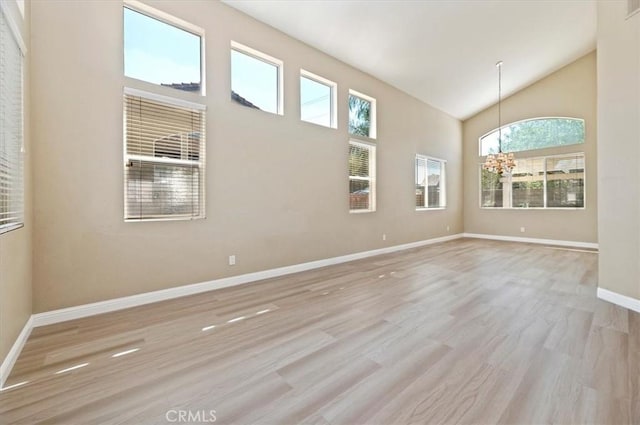 23403 Mountain Song, Murrieta, CA 92562 - empty room featuring baseboards, high vaulted ceiling, a chandelier, and wood finished floors