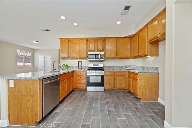 23403 Mountain Song, Murrieta, CA 92562 - kitchen with recessed lighting, a peninsula, light stone countertops, stainless steel appliances, and a sink
