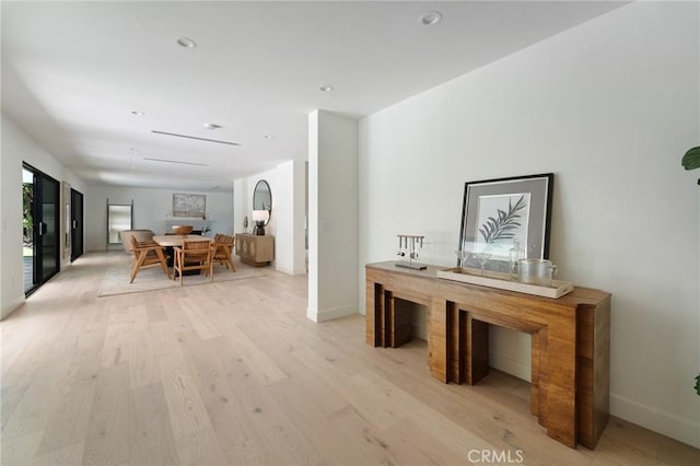 hallway featuring recessed lighting, baseboards, and light wood-style flooring