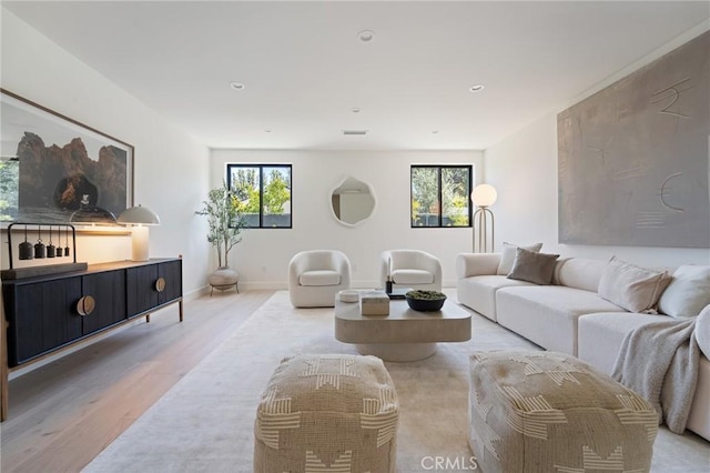 living room with baseboards, recessed lighting, plenty of natural light, and wood finished floors