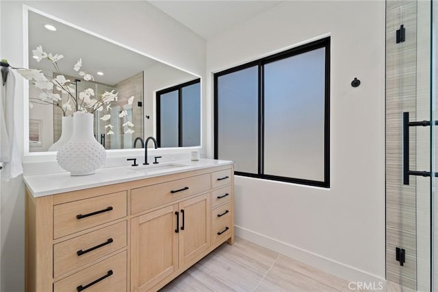 bathroom featuring vanity, baseboards, and a stall shower