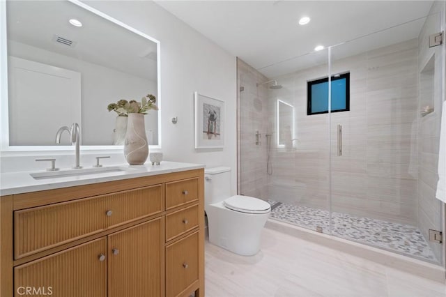 bathroom featuring visible vents, toilet, a stall shower, and vanity