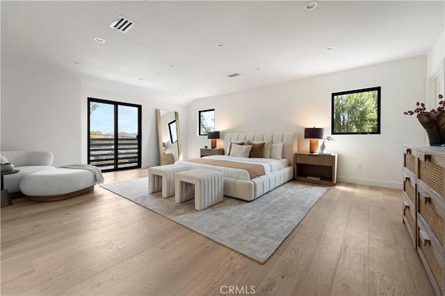 bedroom featuring light wood-type flooring, visible vents, multiple windows, and access to exterior