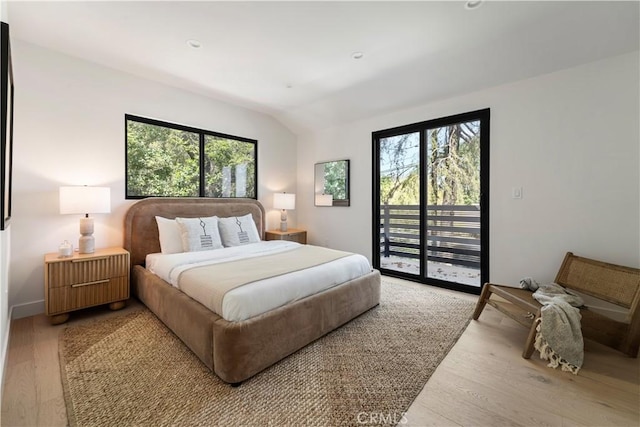 bedroom featuring access to outside, baseboards, vaulted ceiling, and light wood-type flooring