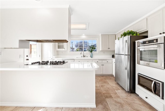 10022 Bismark Dr, Huntington Beach, CA 92646 - kitchen with light countertops, a peninsula, appliances with stainless steel finishes, white cabinetry, and a sink