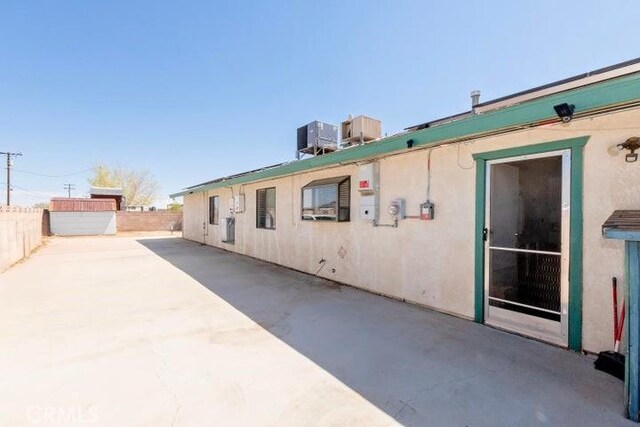 back of property featuring central AC unit, stucco siding, a patio area, and fence