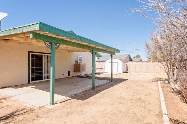 view of patio / terrace featuring a fenced backyard, an outdoor structure, and a storage shed