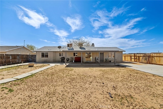 rear view of house featuring a chimney, a fenced backyard, and a patio area