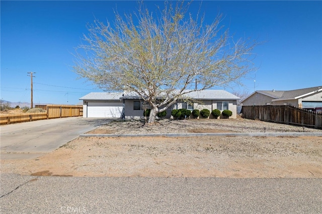 ranch-style house featuring stucco siding, concrete driveway, a garage, and fence